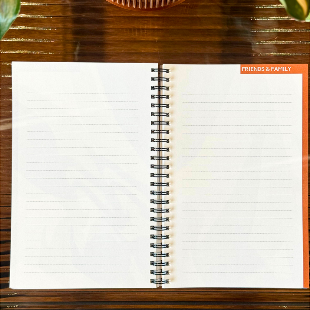 Open notebook on a wooden surface with a plant in the background